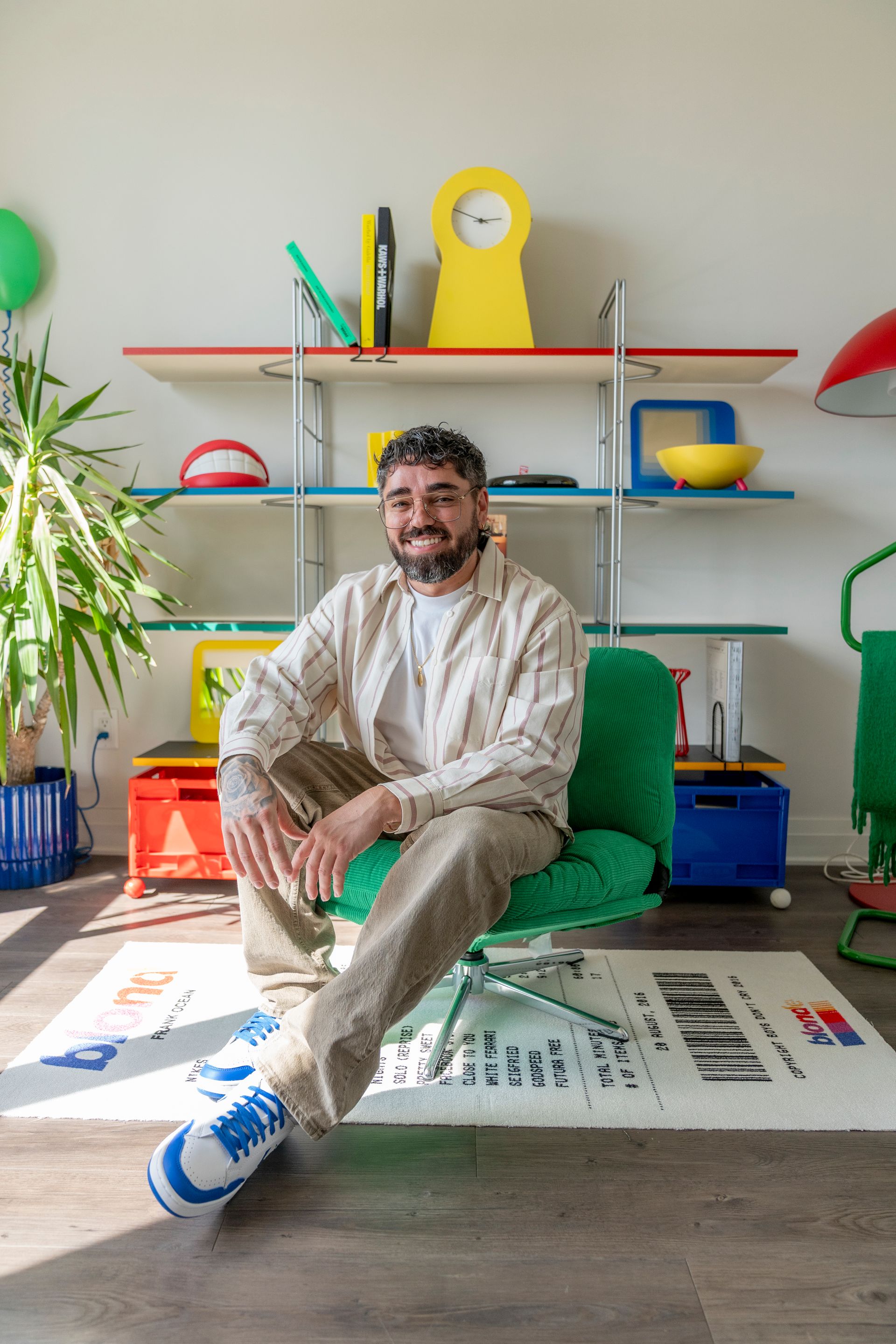 Steve Gonçalves, alias Mister Minimalist, assis dans son intérieur coloré à Montréal entouré d’objets et de mobilier inspirés d’IKEA.