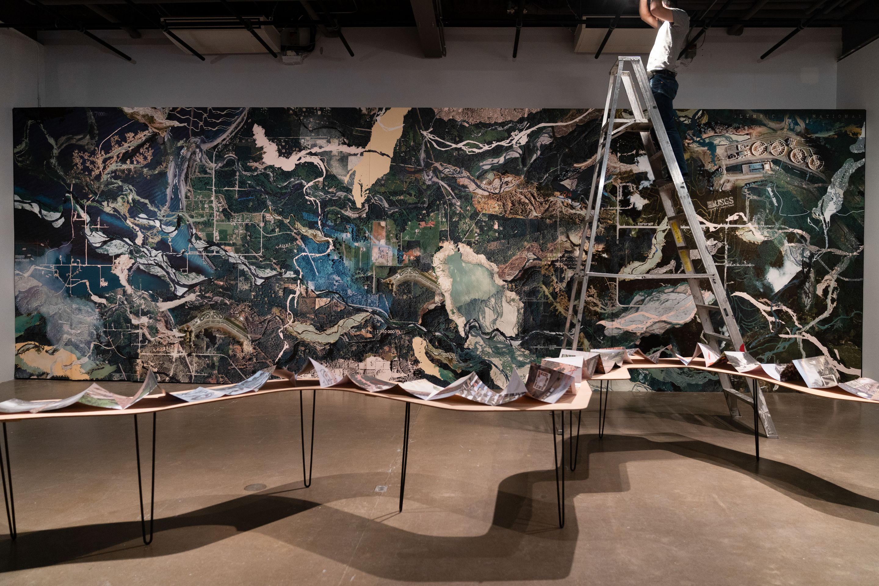 Installation de Carolina Caycedo au centre VU présentant une cartographie monumentale inspirée d’images satellites de la rivière Elwha dans le cadre de Manif d’art 12 à Québec.