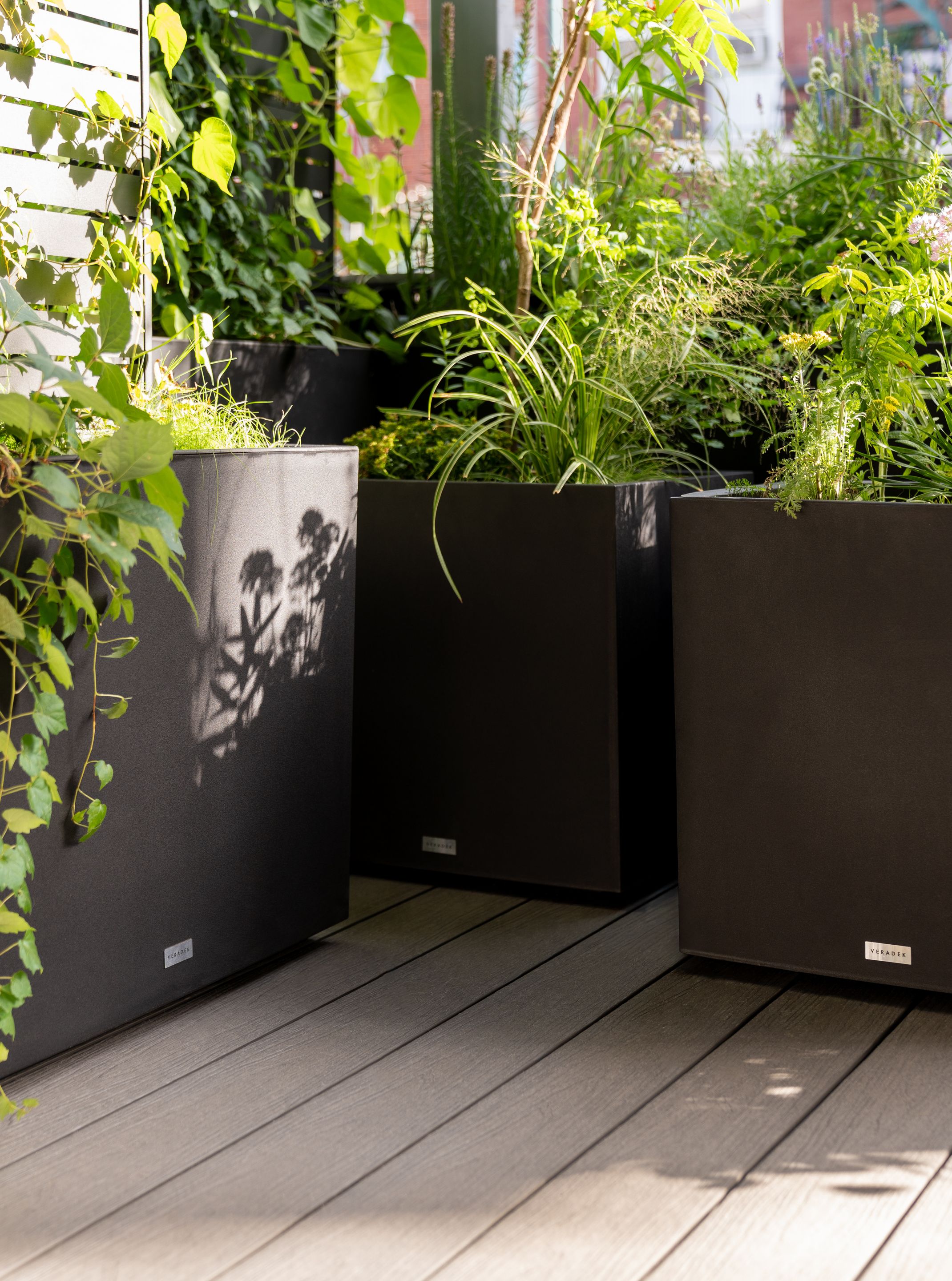 Jardinières noires Veradek de la série Block formant un jardin étagé sur la terrasse Letourneux