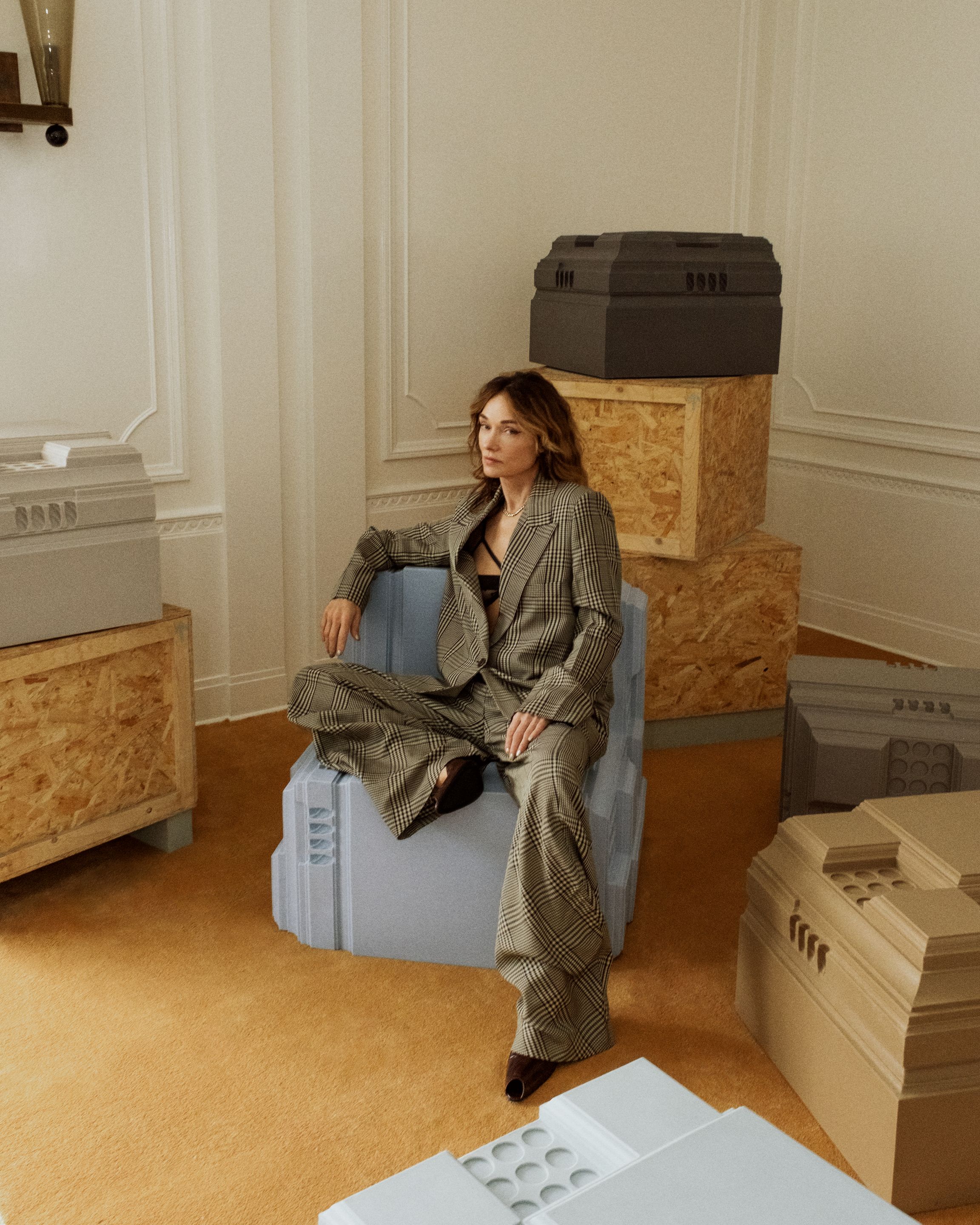 Kelly Wearstler assise sur une assise sculpturale bleue présentée dans l’espace Side Hustle