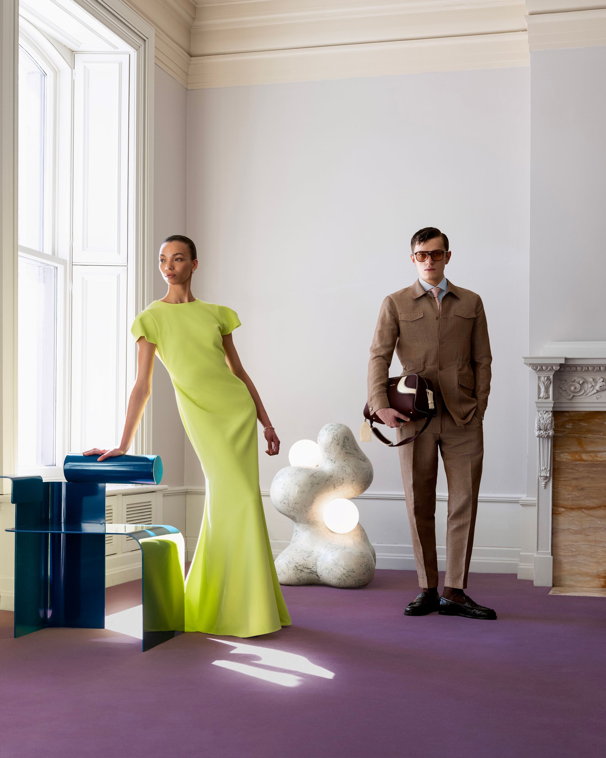 Deux mannequins dans un intérieur patrimonial montréalais entourés de mobilier sculptural et de luminaires contemporains.