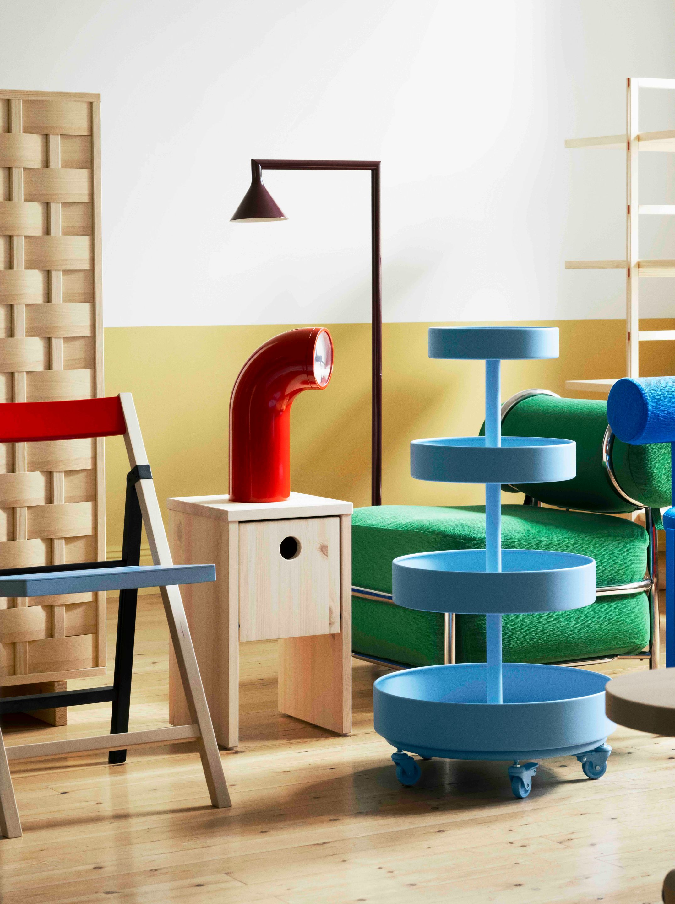 Rangement roulant bleu conçu par Lex Pott, fauteuil gonflable vert et mobilier coloré de la collection IKEA PS 2026 dans un intérieur contemporain.