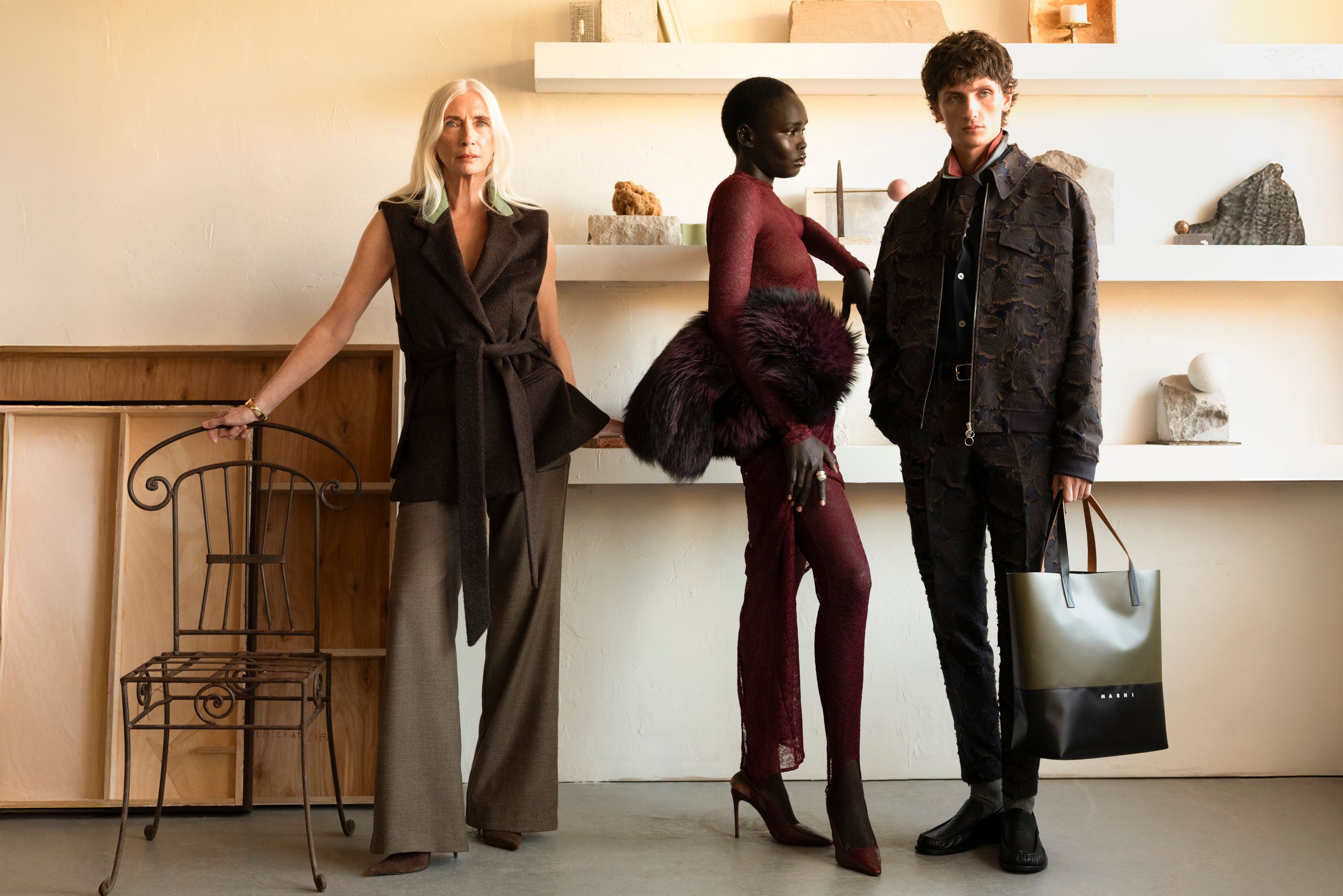 Trois modèles posent dans l’atelier de Jeremy Le Chatelier, entourés d’objets sculpturaux et de mobilier minimaliste.